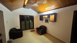 a living room with two chairs and a ceiling at Royal Holiday Homes 4BHK premium Luxury Beach Villa, Uthandi in Chennai