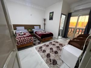 une chambre avec deux lits et un balcon dans l'établissement Aswan City Star, à Assouan