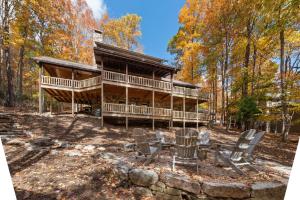 a log cabin in the woods with chairs at Cabin Chateau- Modern Escape with Outdoor Living area with Fireplace & Hot Tub in Baldwin