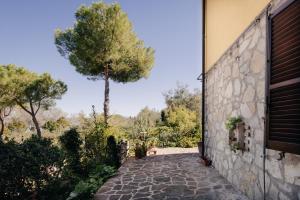 a stone walkway next to a building with a tree at Le Margherite in Castiglione del Lago