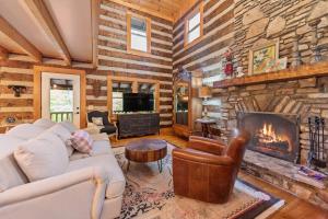 a living room with a fireplace in a log cabin at Cabin Chateau- Modern Escape with Outdoor Living area with Fireplace & Hot Tub in Baldwin