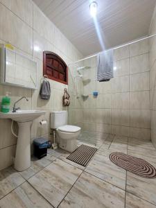 un baño con inodoro y lavabo en Espaço Villa dos Anjos, en Morretes