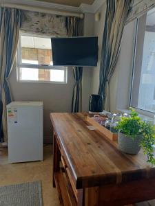 a kitchen with a wooden table and a refrigerator at Eagle's Nest in Mossel Bay