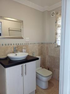 a bathroom with a toilet and a sink and a mirror at Eagle's Nest in Mossel Bay