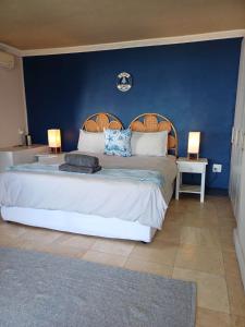 a bedroom with a large bed with a blue wall at Eagle's Nest in Mossel Bay