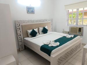 a bedroom with a bed with two white towels on it at Candolim apartment in Candolim