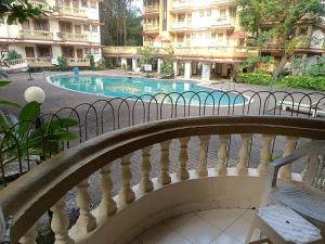 a balcony with a view of a swimming pool at Candolim apartment in Candolim +10 photos