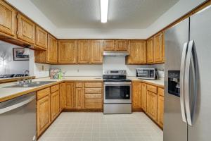 a kitchen with wooden cabinets and stainless steel appliances at 12 Mi to Dtwn St Paul Extended Stay in Woodbury! in Woodbury +27 photos