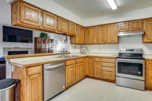 a kitchen with wooden cabinets and a stove top oven at 12 Mi to Dtwn St Paul Extended Stay in Woodbury! in Woodbury