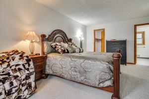 a bedroom with a bed and a lamp on a dresser at 12 Mi to Dtwn St Paul Extended Stay in Woodbury! in Woodbury