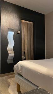 een hotelkamer met een bed en een spiegel bij LES VOYAGEURS - Vairé in Vairé