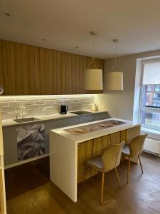 a kitchen with a counter and two chairs in it at Stilingas dviejų kambarių butas in Vilnius