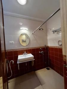 une salle de bain avec un lavabo et un miroir dans l'établissement Tha Villa Calangute, à Calangute