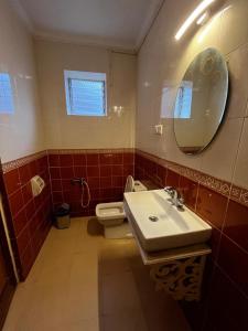 a bathroom with a sink and a toilet and a mirror at Tha Villa Calangute in Calangute