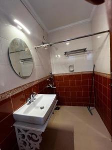 une salle de bain avec un lavabo et un miroir dans l'établissement Tha Villa Calangute, à Calangute