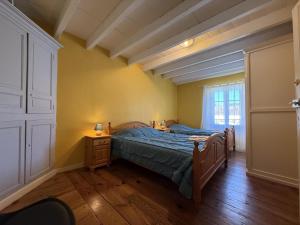 サン・ペ・シュル・ニヴェルにあるMaison "harotcheta"のベッドとドレッサーと窓のある寝室