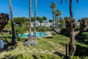 ein Resort mit Swimmingpool und Palmen in der Unterkunft 2bed apartment in Miraflores in Sitio de Calahonda