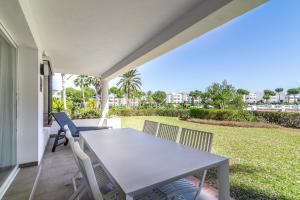 eine Terrasse mit Tisch und Stühlen auf einer Veranda in der Unterkunft 2bed apartment in Miraflores in Sitio de Calahonda