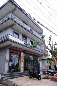 un bâtiment avec deux motos garées devant lui dans l'établissement Namami Atithi Grah, à Barsāna