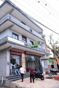 un groupe de personnes debout à l'extérieur d'un bâtiment dans l'établissement Namami Atithi Grah, à Barsāna