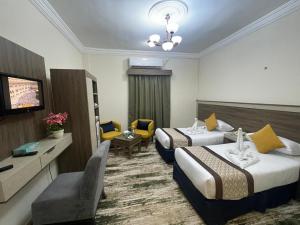 a hotel room with two beds and a television at فندق فجر الرسالة in Al ‘Azīzīyah