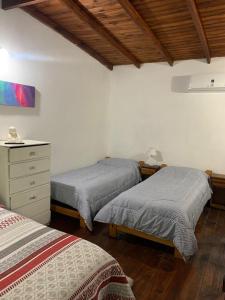 a bedroom with two beds and a dresser at Disfrutá tu estadía en Romana Dolores a solo 10 cuadras del parque termal Conseguí un ahorro exclusivo para el parque in Dolores