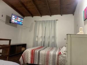 a bedroom with a bed and a tv on the wall at Disfrutá tu estadía en Romana Dolores a solo 10 cuadras del parque termal Conseguí un ahorro exclusivo para el parque in Dolores