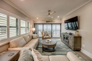 a living room with a couch and a flat screen tv at Sand Pointe 137 in Sanibel