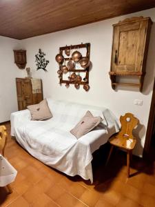a bedroom with a white bed and a wooden floor at Cesa Alpes 2 in Campitello di Fassa