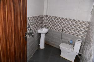 une petite salle de bain avec toilettes et lavabo dans l'établissement Namami Atithi Grah, à Barsāna