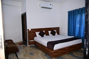 une chambre avec un lit et une chaise dans l'établissement Namami Atithi Grah, à Barsāna