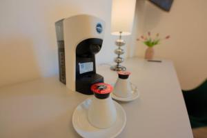 two white vases on a counter with a coffee maker at Camera Helsinki - La Casa di Carta Affittacamere in Udine