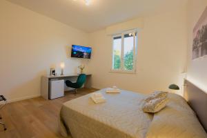 a bedroom with a bed and a desk and a window at Camera Helsinki - La Casa di Carta Affittacamere in Udine