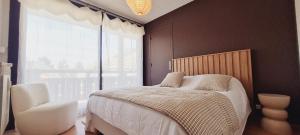 une chambre avec un lit et une grande fenêtre dans l'établissement Eperon 1 NA2 - 3P4, à Les Deux Alpes