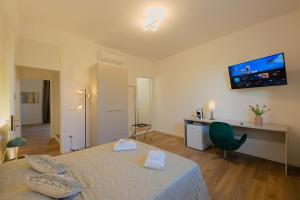 a bedroom with a large bed with a television on the wall at Camera Helsinki - La Casa di Carta Affittacamere in Udine