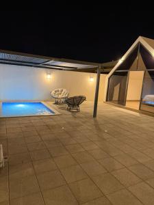 a patio with a swimming pool at night at ستاي إن Stay Inn in Nizwa