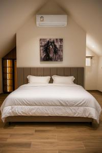 a bedroom with a large white bed and a wall at ستاي إن Stay Inn in Nizwa