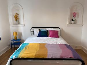 a bedroom with a bed with a colorful blanket at 4-Bedrooms - Perfect for those working in Bridgend in Bridgend