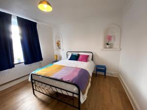 a bedroom with a bed with colorful sheets and a window at 4-Bedrooms - Perfect for those working in Bridgend in Bridgend