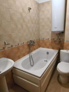 a bathroom with a tub and a toilet and a sink at Apartament 4 seasons - Top Lodge in Bansko