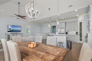 Inlet Beach - 70 Pinecrest في بنما سيتي بيتش: مطبخ وغرفة طعام مع طاولة وكراسي خشبية