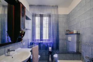 a blue tiled bathroom with a sink and a toilet at Le Margherite in Castiglione del Lago +62 photos