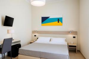 a bedroom with a bed and a desk and a painting at Hotiday La Spezia Centrale in La Spezia