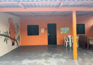 a room with orange walls and a table and chairs at Casa Laranja in Presidente Figueiredo