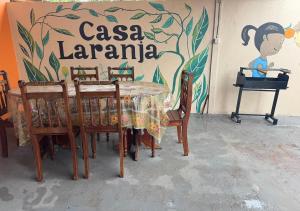 a table and chairs in front of a wall with a sign at Casa Laranja in Presidente Figueiredo