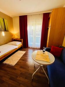 a living room with a table and a couch at Pension am Campus Velden in Velden am Wörthersee