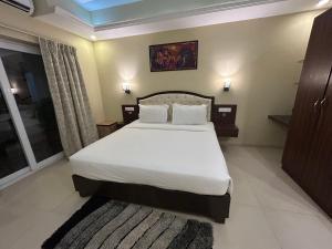 a bedroom with a large bed with white sheets at Casa goa in Calangute