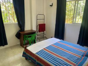 Un dormitorio con cama, escritorio y ventanas en Bamboo Tree Villa, 