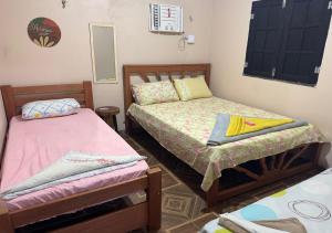 a room with two beds and a mirror at Casa Laranja in Presidente Figueiredo