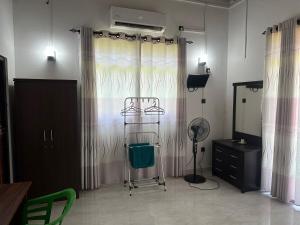 Una habitación con cortinas, una silla y un espejo. en Bamboo Tree Villa, 